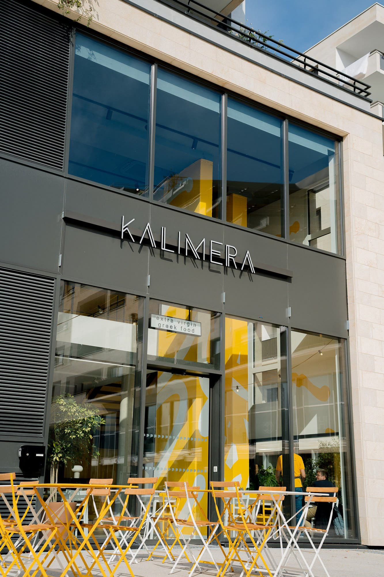 KALIMERA Bordeaux from the street: the sign above the glass front, and the yellow chairs of the terrace