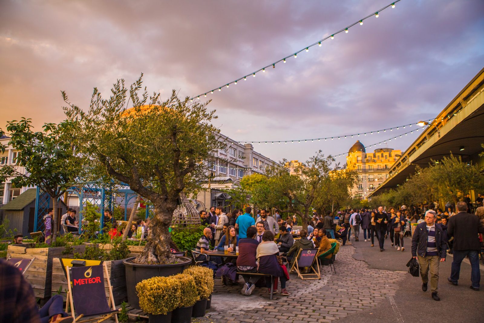 The terrace at Ground Control in Paris at dusk, with its olive tree and strings of lights